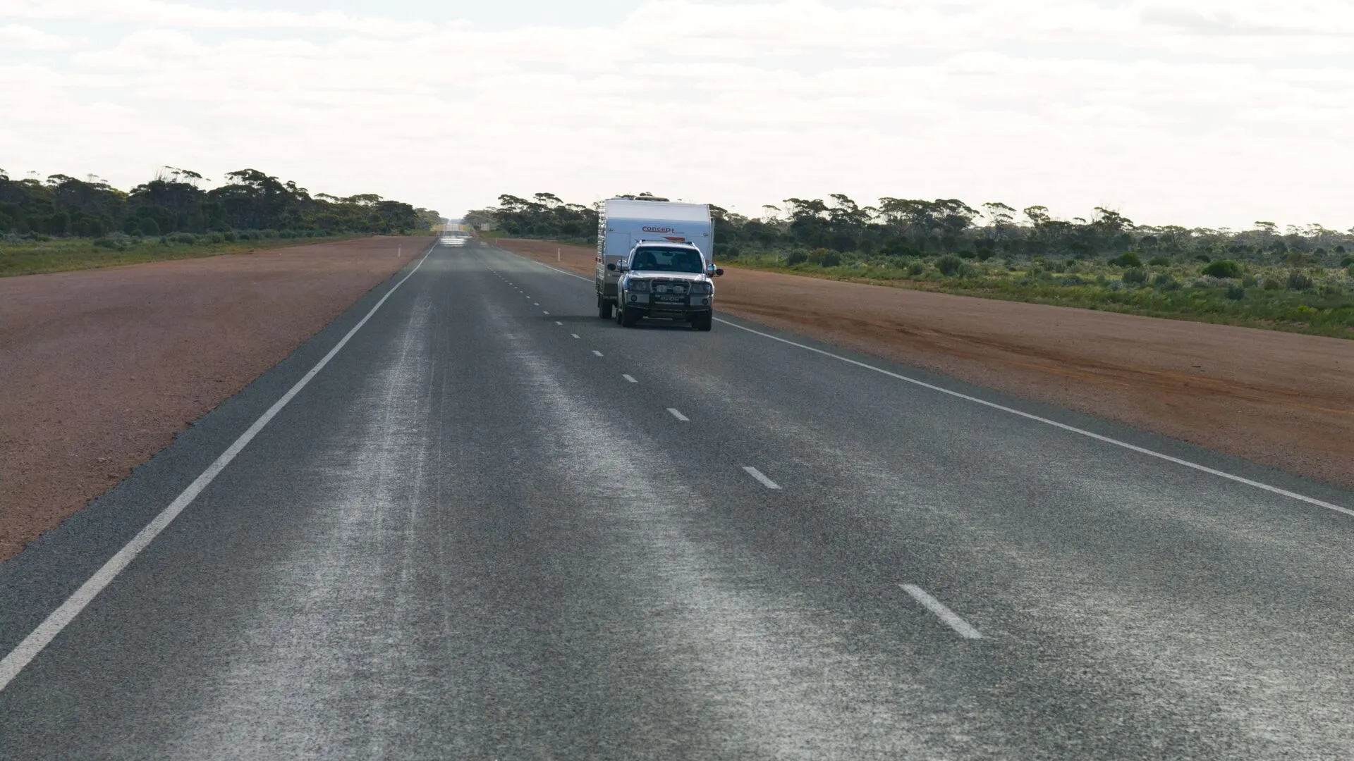 A vehicle on an open highway through the Australian bush